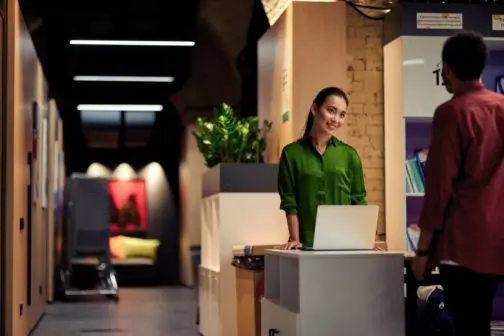 Employee entering the building premises, stood next to the visitor authentication and management system